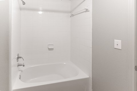 a white bathroom with a tub and a shower