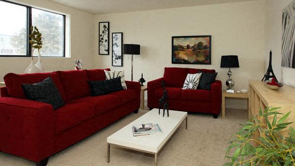 a living room with a red couch and a white table
