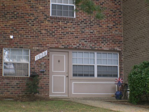 the front door of a brick house with a street sign on it