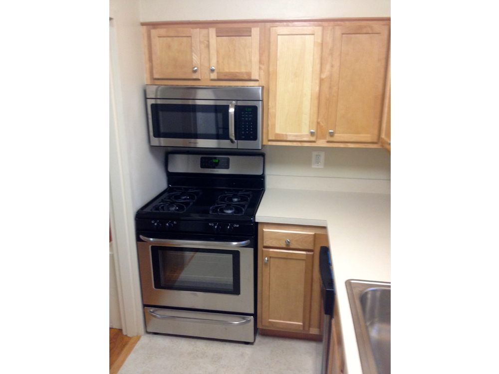 a kitchen with stainless steel appliances and wooden cabinets