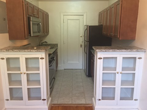 a kitchen with cabinets and a refrigerator and a door