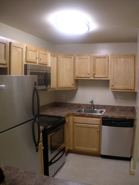 a kitchen with stainless steel appliances and wooden cabinets