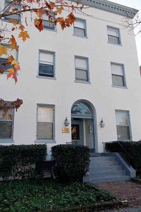 a white building with a blue door and stairs