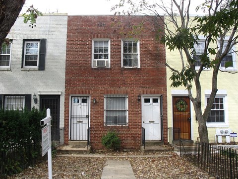 the front of a brick house with two white doors