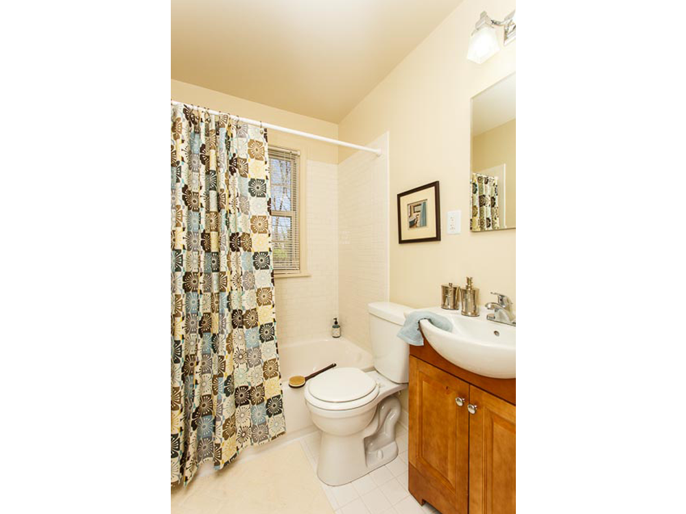 a bathroom with a toilet and a sink and a shower curtain