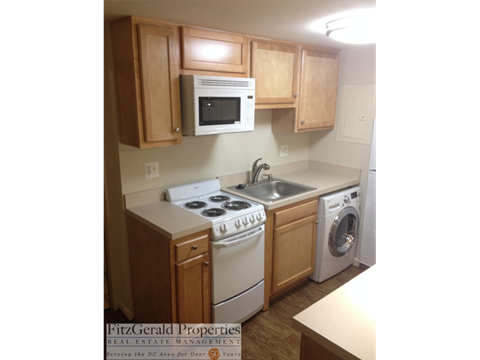 a small kitchen with white appliances and wooden cabinets