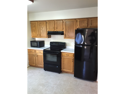 a kitchen with black appliances and wooden cabinets