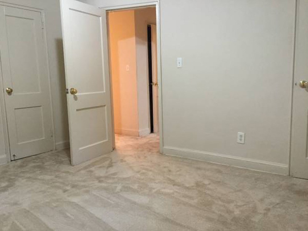 an empty room with a door open and a closet