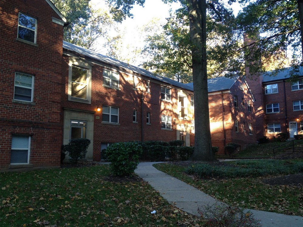 an apartment building with a sidewalk in front of it
