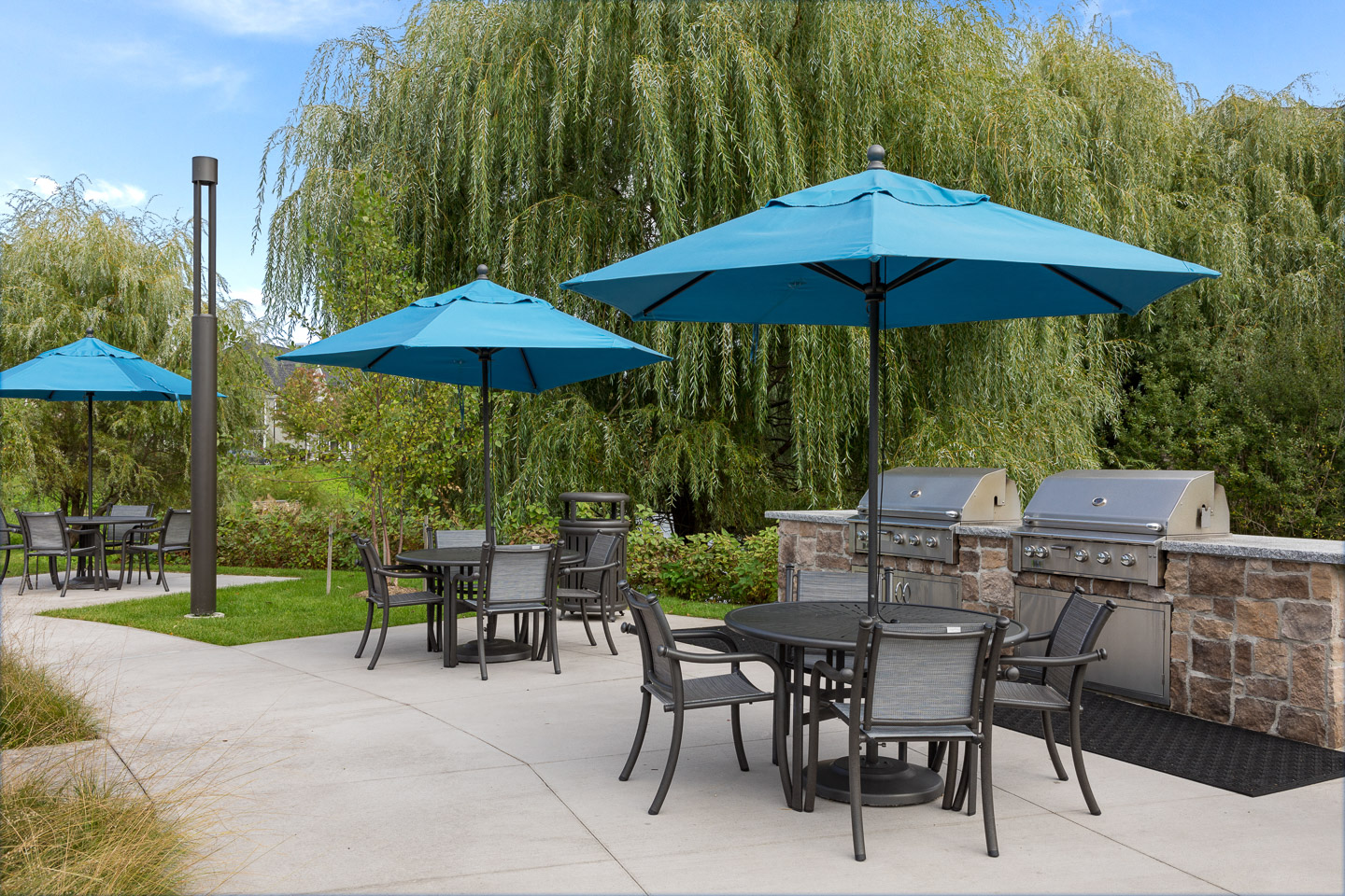 a patio with tables and chairs and umbrellas