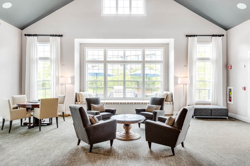 a living room with couches and chairs and a large window