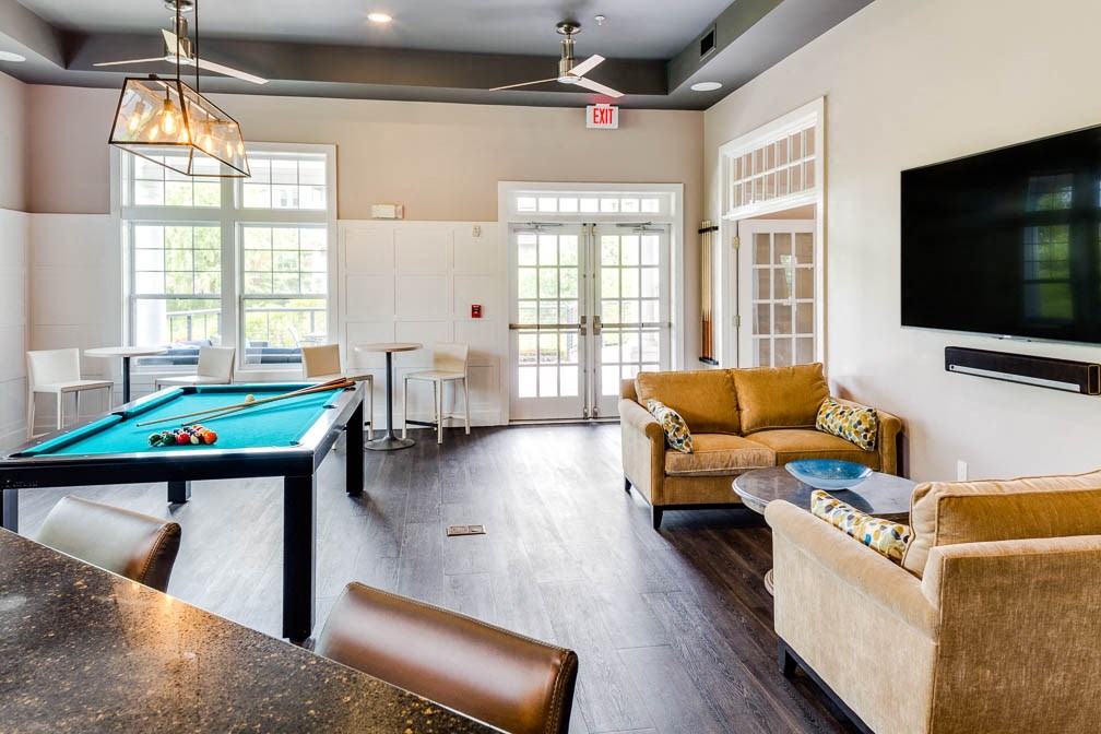 a living room with a pool table and a tv
