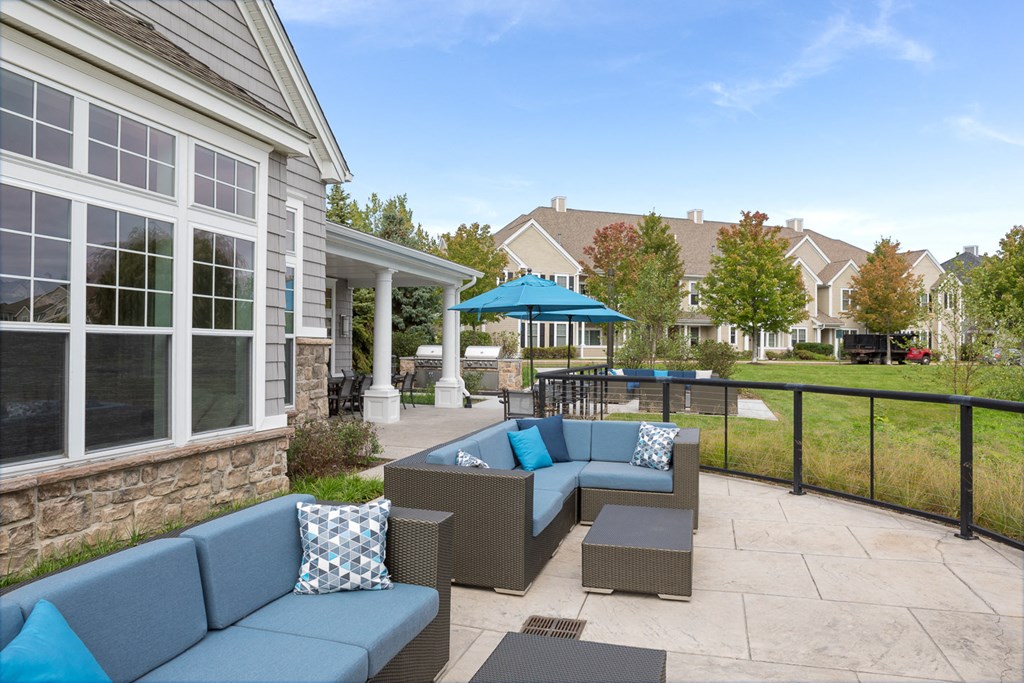 a patio with blue couches and chairs and a table
