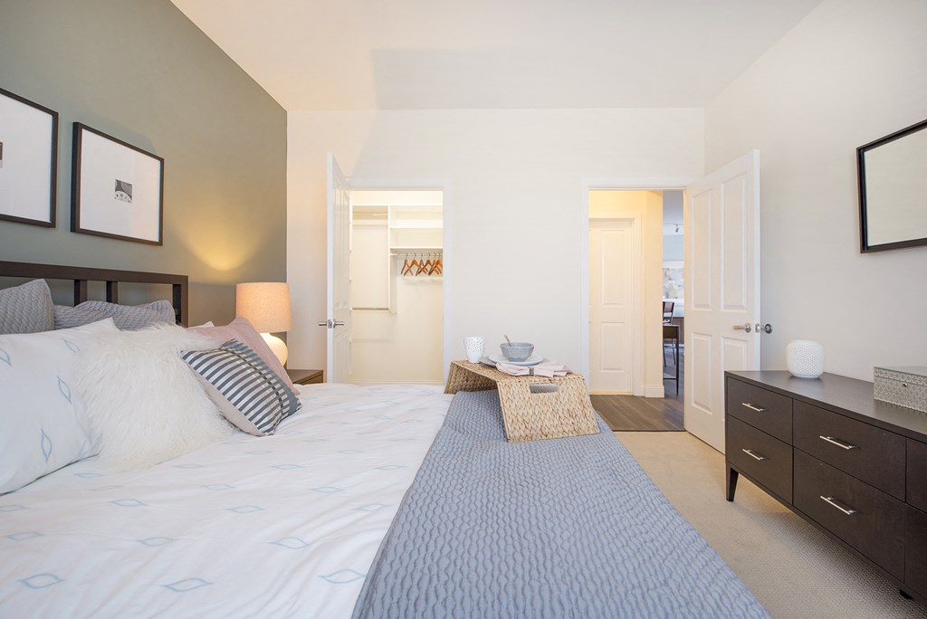 a bedroom with a bed and a dresser and a bathroom