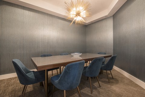a dining room with a long wooden table and blue chairs