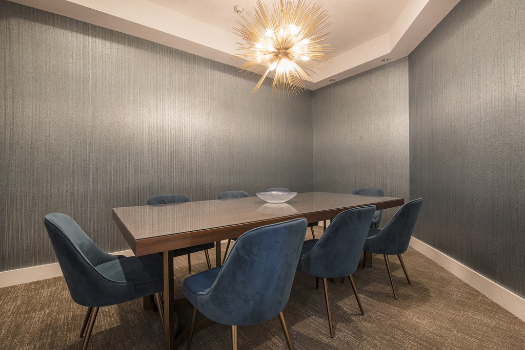 a dining room with a long wooden table and blue chairs