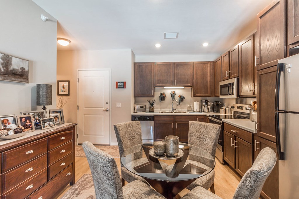 a kitchen with wooden cabinets and a table with chairs