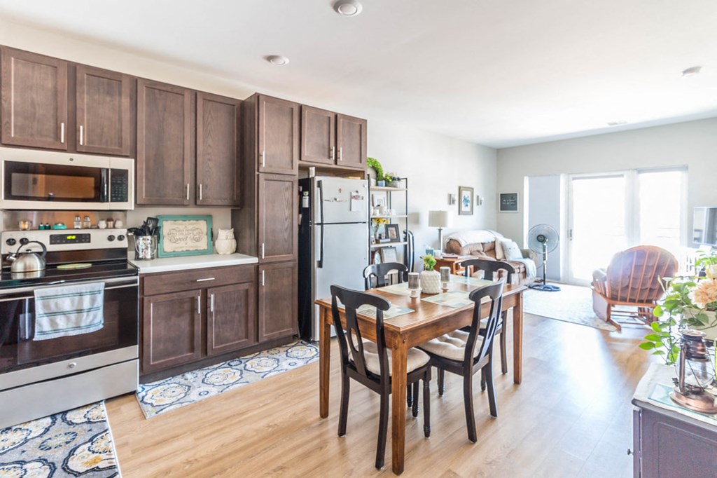 a kitchen with wooden cabinets and a wooden table