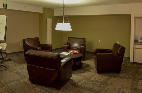 a living room with leather chairs and a table