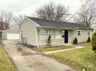 the front of a house with a driveway and a garage door