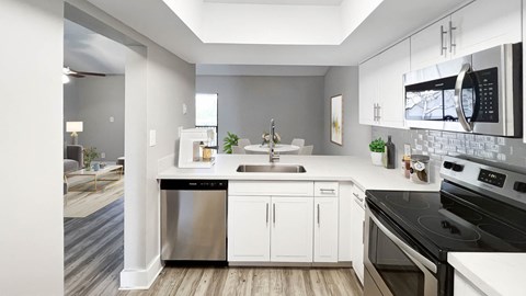 a kitchen with white cabinets and stainless steel appliances
