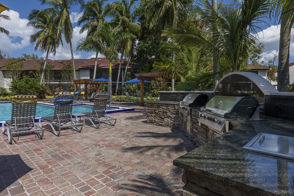 a resort style swimming pool with a grill and chairs