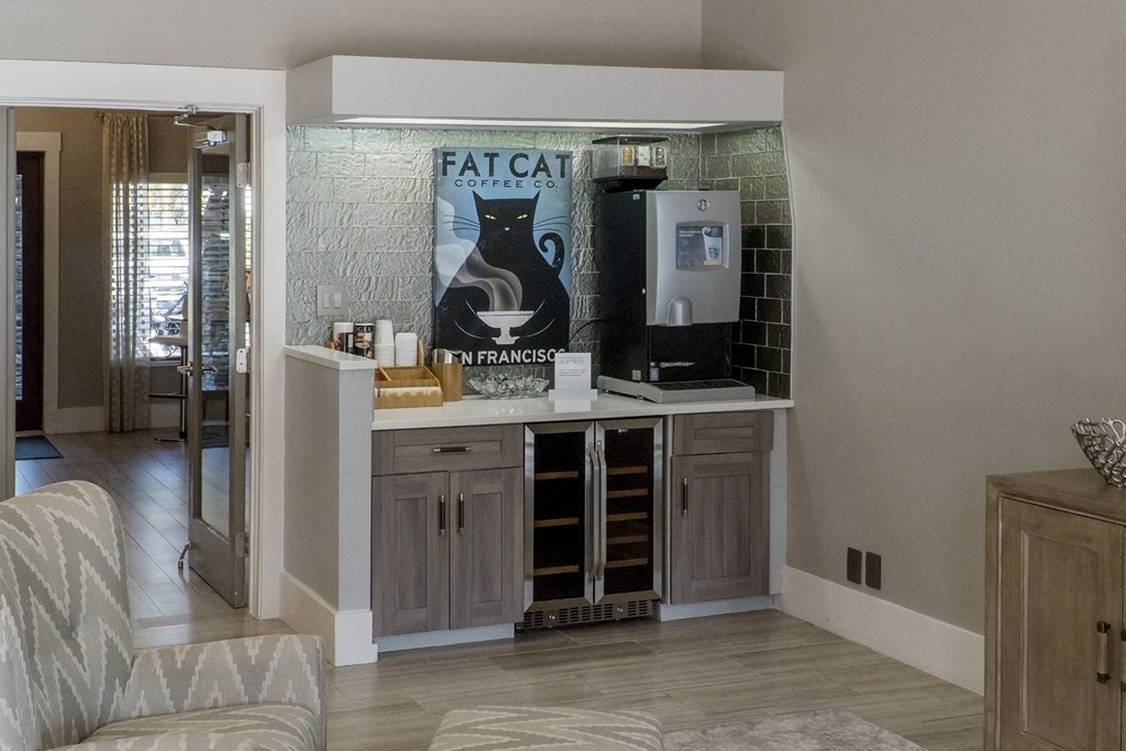 a kitchen with a bar and a cat poster on the wall