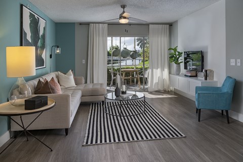 a living room with blue walls and a sliding glass door to a balcony
