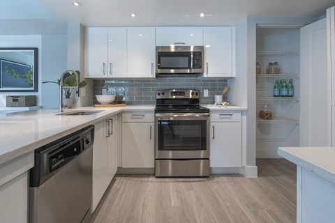 a kitchen with stainless steel appliances and white cabinets
