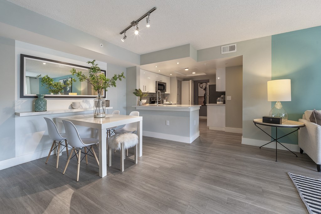 a living room and dining room with a table and chairs
