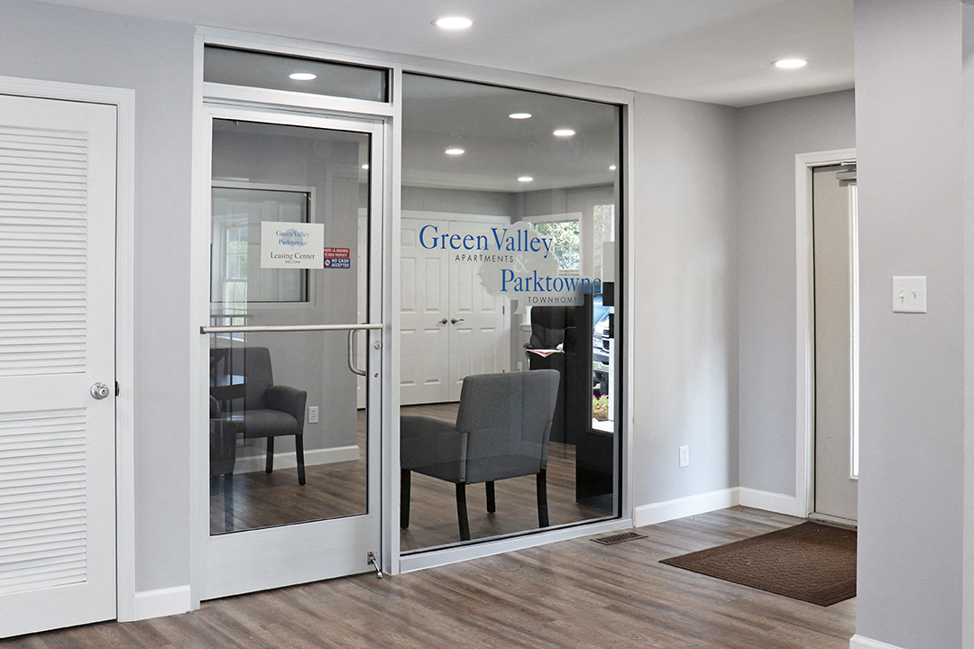 a lobby with glass doors and a table and chairs