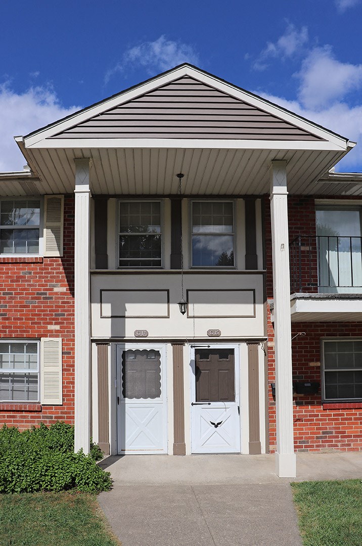 a red brick house with white doors and a porch