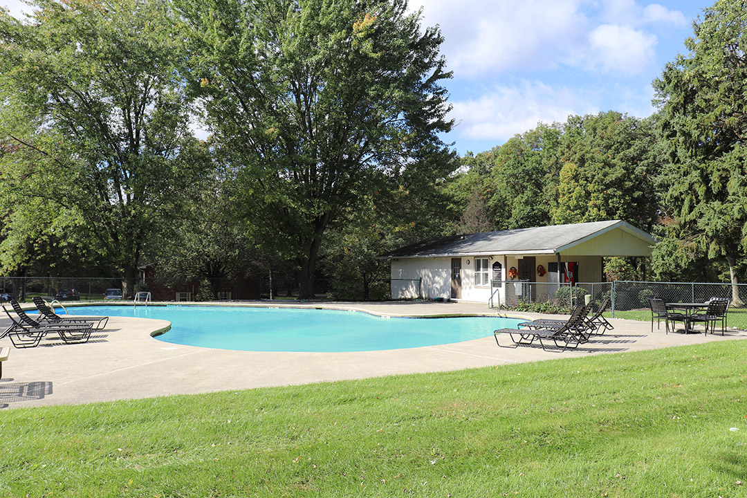 a swimming pool with a pavilion and chairs around it