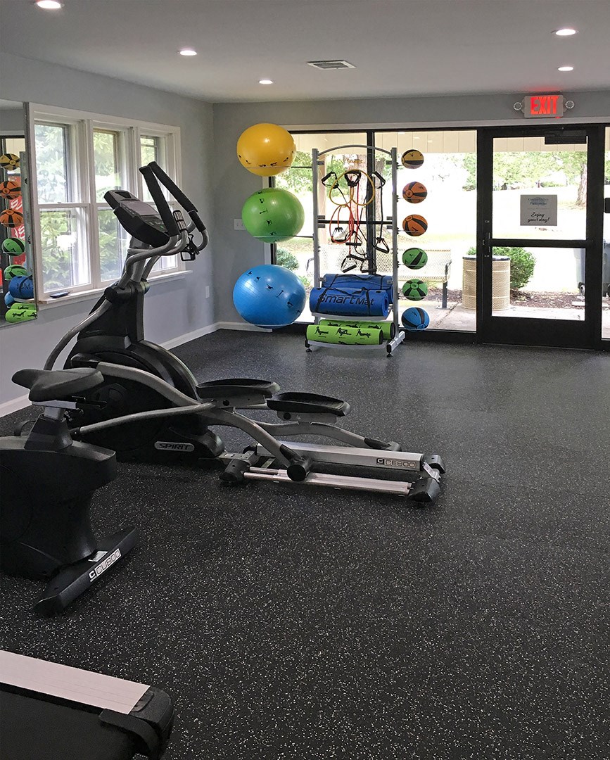 a gym with a reformer and weights on the floor