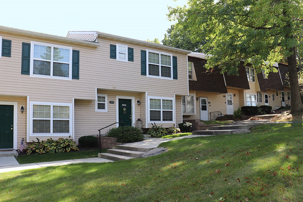 a white house with green shutters and a lawn
