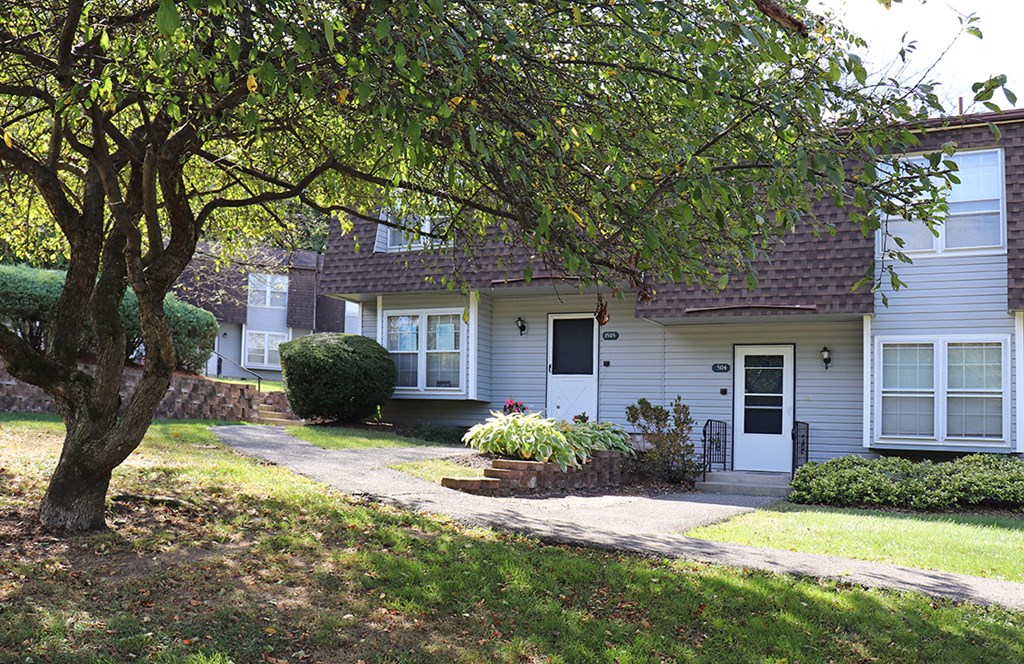 a white house with a tree in front of it