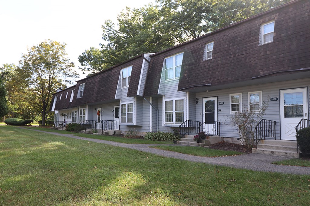 a row of houses on the side of a sidewalk