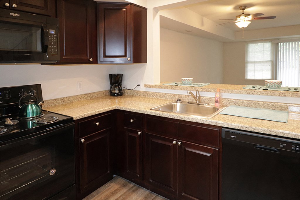 a kitchen with wooden cabinets and granite counter tops and a sink