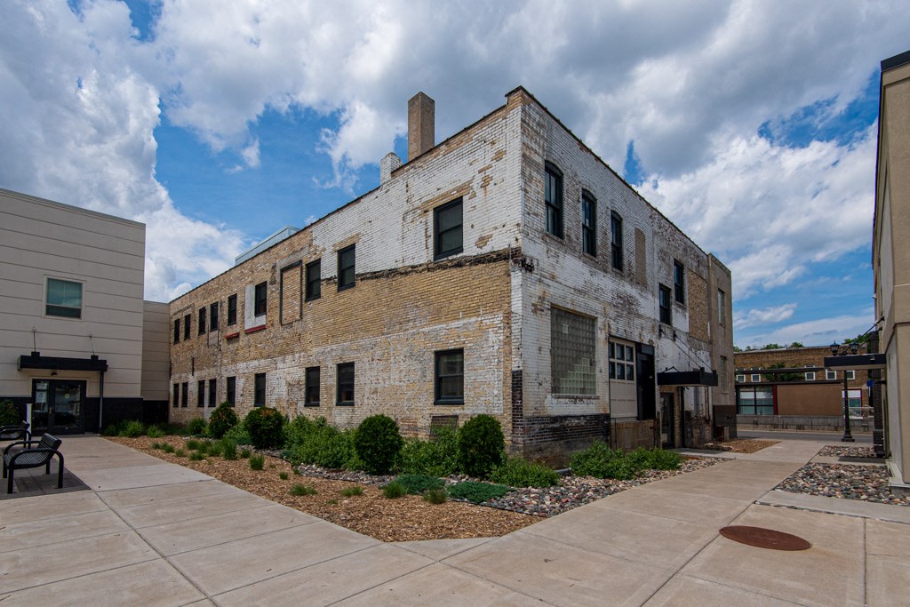 the exterior of a brick building with a courtyard in front of it
