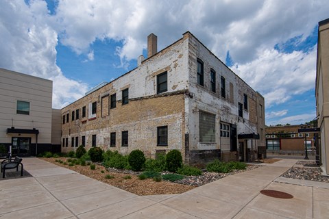 the exterior of a brick building with a courtyard in front of it