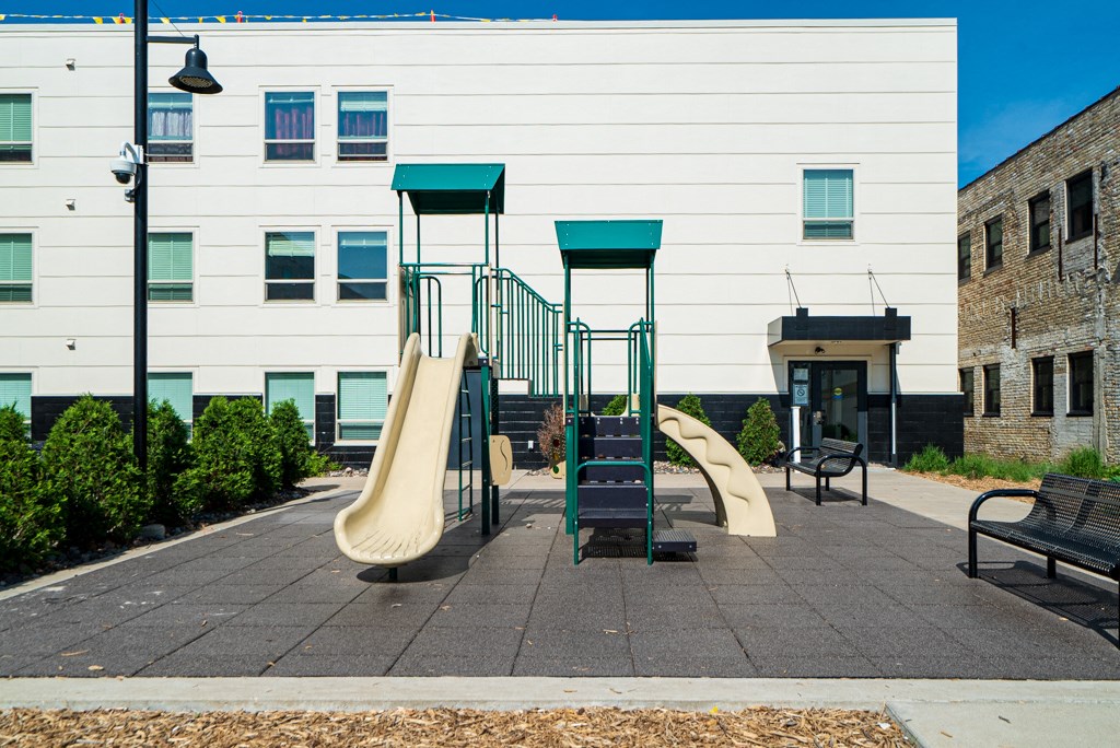 a playground with slides in front of a building