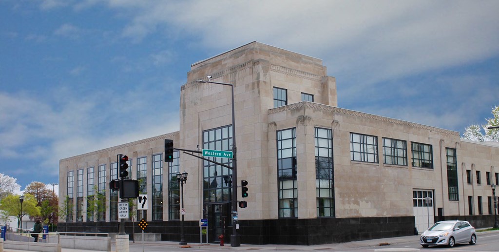 a large building with a street sign in front of a traffic light