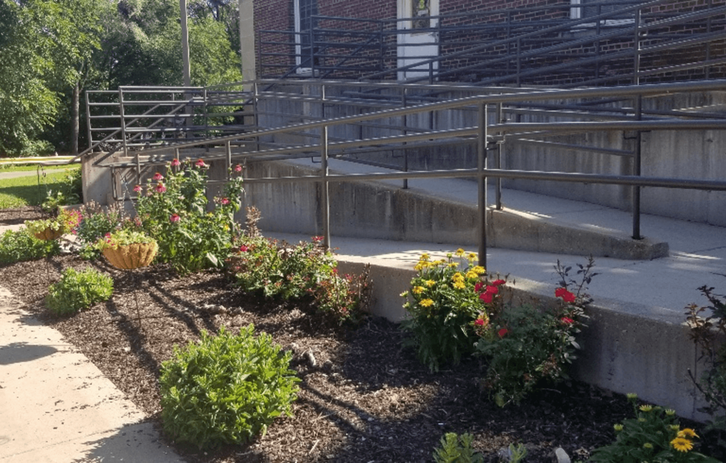 a garden in front of a building with stairs
