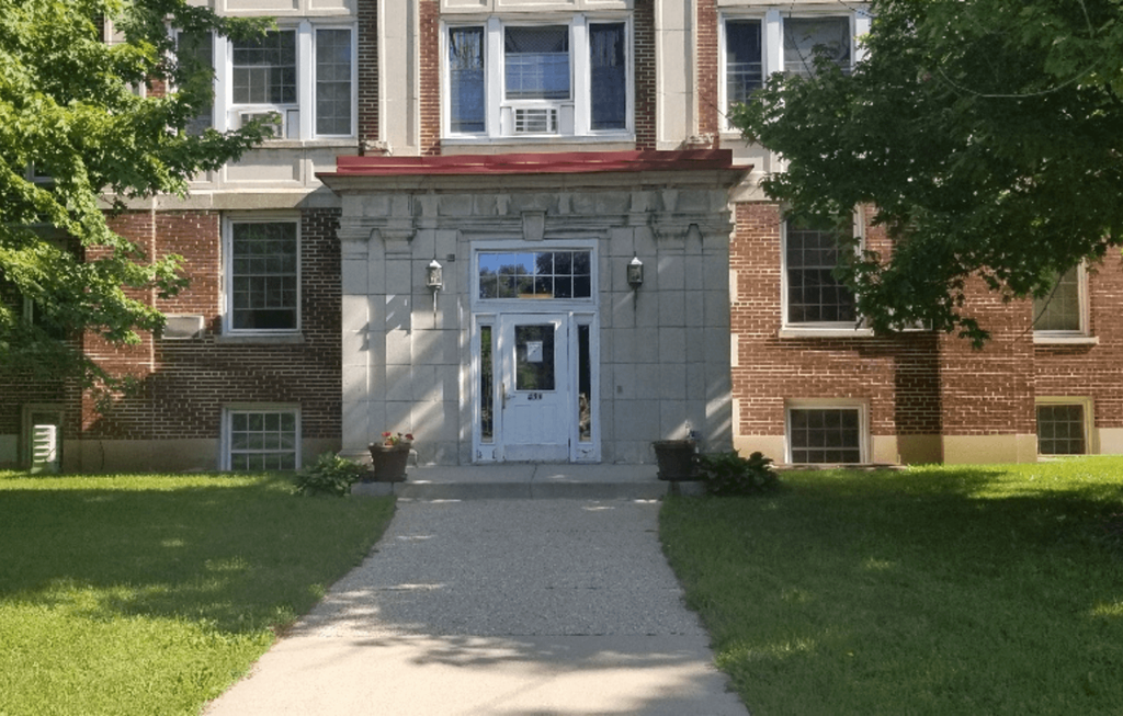 the front of a brick house with a white door