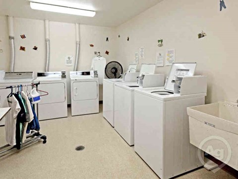 A laundry room with washers and dryers.