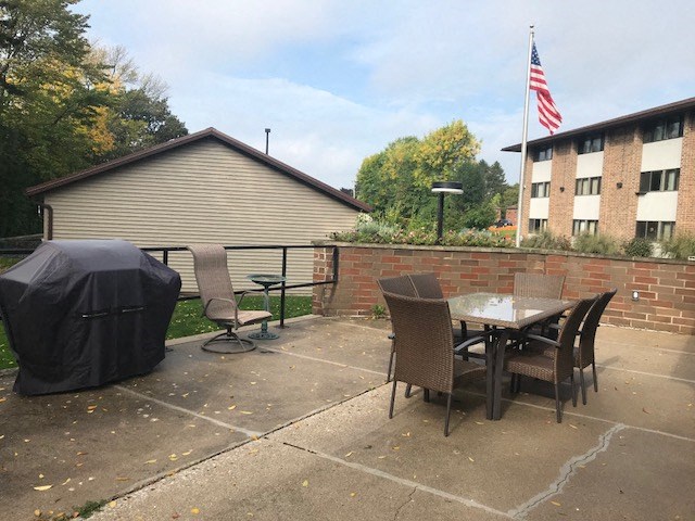 a patio with a table and chairs and an flag