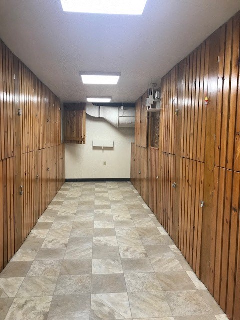 a room filled with wooden lockers and a tile floor