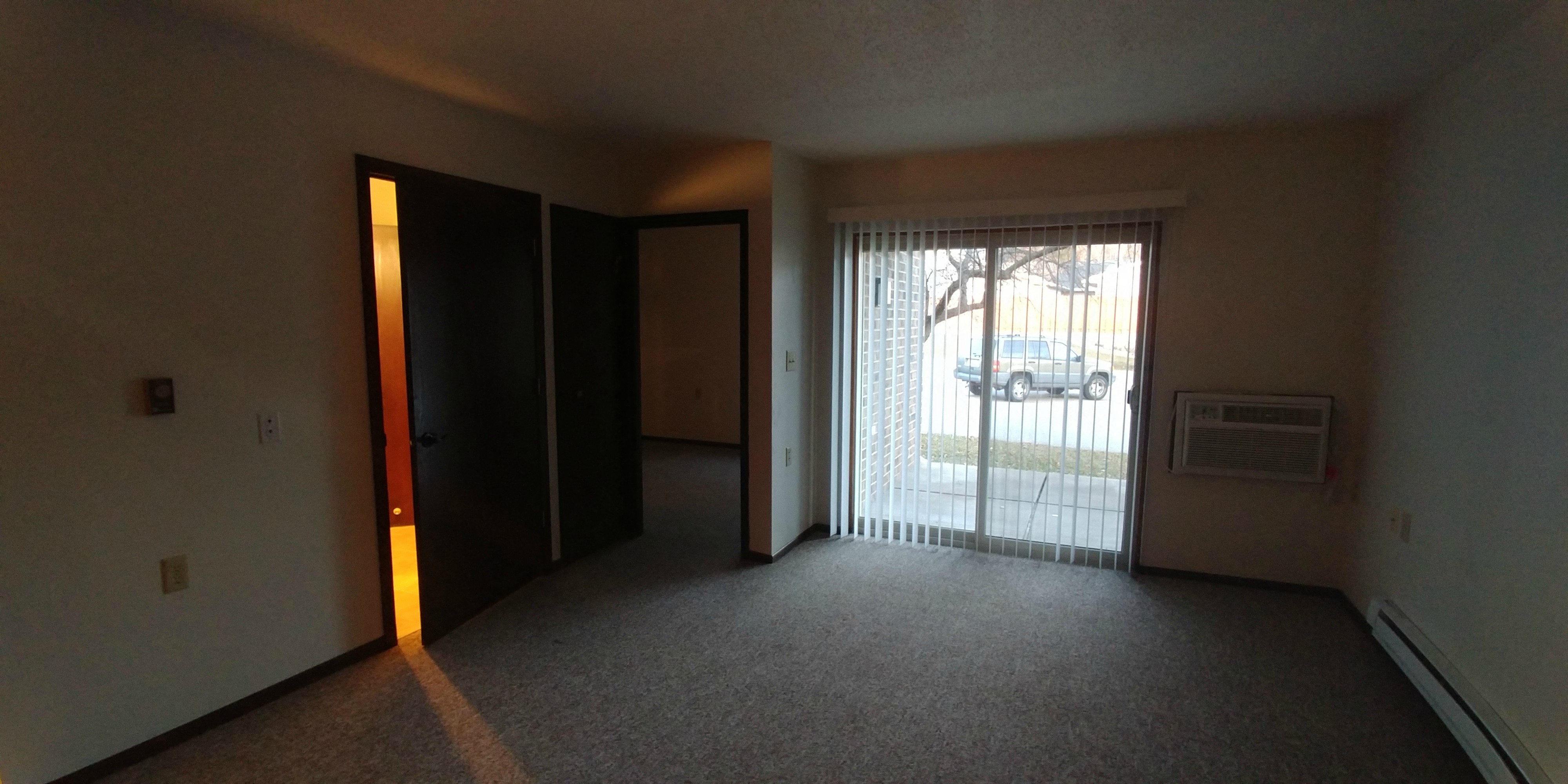 an empty living room with a window and a door