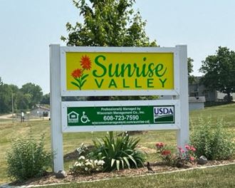 a sign for sunrise valley in front of a park