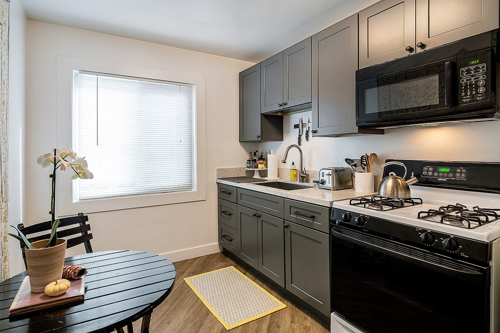 a kitchen with black appliances and a black dining table